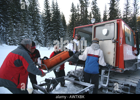 Trägt eine Mädchen auf einer Bahre aus einer Ski-Krankenwagen Sanitäter Stockfoto