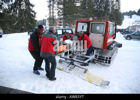 Trägt eine Mädchen auf einer Bahre aus einer Ski-Krankenwagen Sanitäter Stockfoto