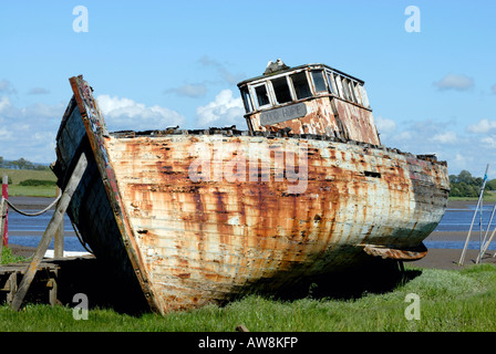Das Boot „Gute Hoffnung“ sitzt am Ufer, sein rosteter Rumpf ist ein Zeugnis der Zeit und der Elemente, eine Erinnerung an die maritime Geschichte. Stockfoto