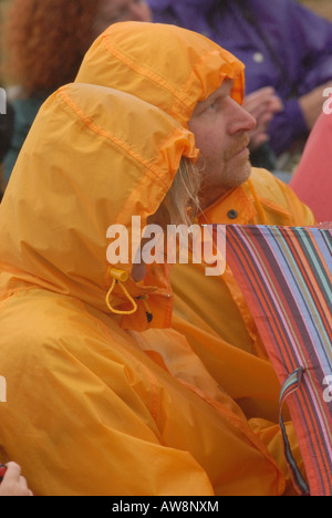 ein Mann und eine Frau männliche und weibliche Mann und Frau zwei Personen tragen Pac-pro-Mac Regenmäntel wasserdichte Kleidungsstücke in einem Platzregen Stockfoto