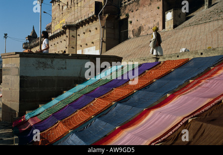 Saris Trocknen auf den Ghats Mann meditiert, Varanasi, Uttar Pradesh, Indien Stockfoto