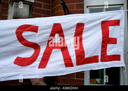 Jumble Sale Banner außerhalb Dorfhalle in rot und weiß Stockfoto