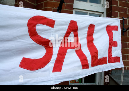 Jumble Sale Banner außerhalb Dorfhalle in rot und weiß Stockfoto