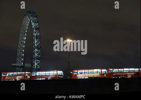 London Eye in der Nacht und eine Warteschlange von Bussen auf Waterloo Bridge Stockfoto