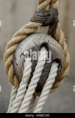 Ein traditioneller Flaschenzug Block hat drei Garben und ist aus Holz die Seile sind Naturfasern Stockfoto