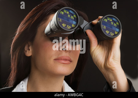 Frau, die durch ein Fernglas Stockfoto