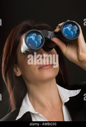 Frau, die durch ein Fernglas Stockfoto