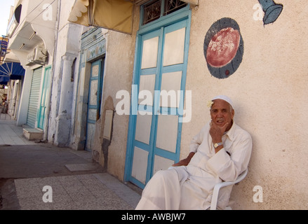 Typische Straßenszene in der arabischen Welt, ein Alter Mann in weiß gekleidet mit einem Jasmin Blume hinter dem Ohr. Stockfoto