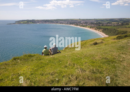 Paar saß auf Klippe Top Blick über Swanage Bay Dorset UK Stockfoto