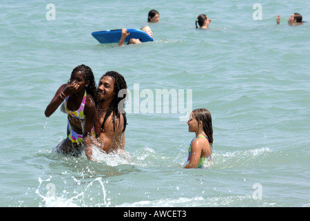 Ethnische schwarze Familie am Strand Spaß im Meer zusammen an einem heißen Sommertag Stockfoto