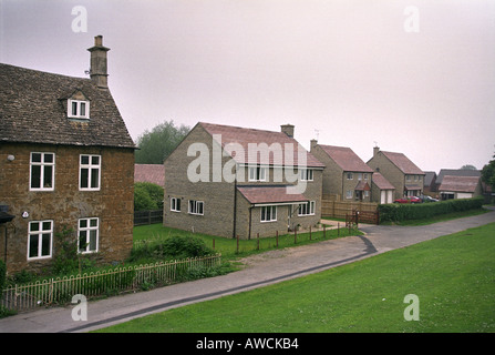 MODERNE IMMOBILIEN EINFAMILIENHAUS IN DER NÄHE VON EINEM ALTEN HAUS IM DORF VON CAM GLOUCESTERSHIRE Stockfoto