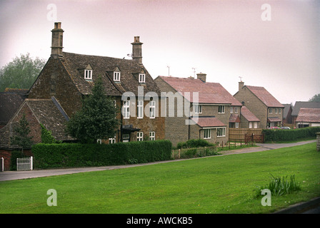 MODERNE IMMOBILIEN EINFAMILIENHAUS IN DER NÄHE VON EINEM ALTEN HAUS IM DORF VON CAM GLOUCESTERSHIRE Stockfoto