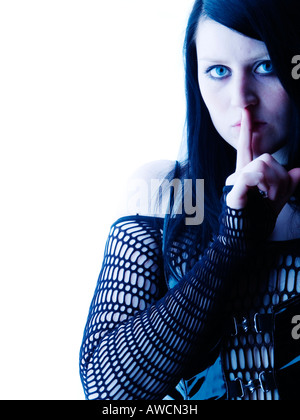 Frau, die Finger an die Lippen, Goth-Stil Stockfoto