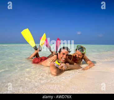 Junges Paar mit Schnorchelausrüstung im flachen Wasser, Strand, Malediven, Indischer Ozean Stockfoto