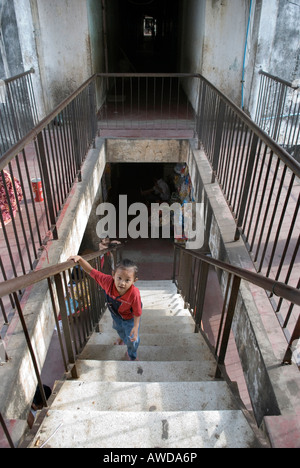 Junge im Treppenaufgang des faulen Wohnung block, Dey Krahom Slumgebiet, Phnom Phen, Kambodscha Stockfoto