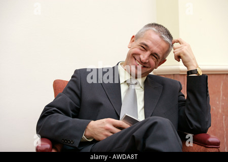 Lächelnde Buisnessman sitzt auf Sessel Stockfoto