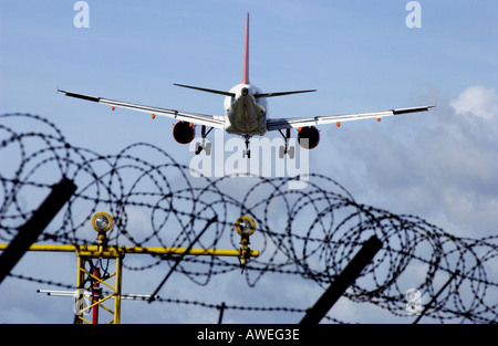 Ein EasyJet-Jet landet am Flughafen Gatwick über den Stacheldraht-Umzäunung Stockfoto