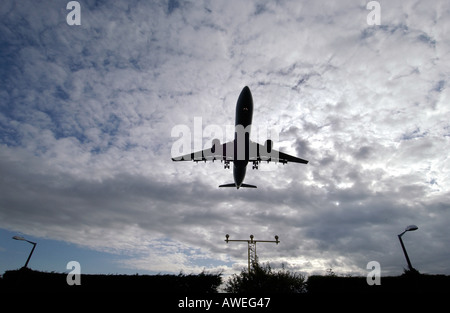 Jet, die hereinkommen, landen am Flughafen Gatwick über den Stacheldraht-Umzäunung Stockfoto