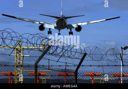 American Airlines Airbus-Jet kommt ins Land am Flughafen Gatwick über Stacheldraht-Umzäunung Stockfoto