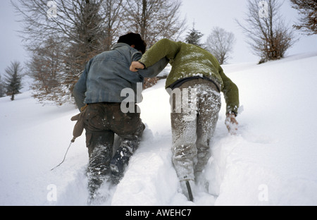 Schneiden eine Spur durch den Tiefschnee zu ihren Schlitten in einer Scheune über dem Dorf von Jidegsegpataka Siebenbürgen Rumänien Stockfoto