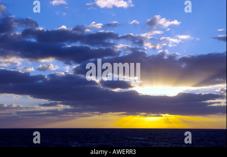 Sonnenuntergang mit Sunburst und Wolken über dem Atlantischen Ozean von einem Kreuzfahrtschiff. Stockfoto