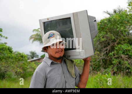 Mann trägt Fernseher zu seinem Haus, einheimischen Arawak, Santa Mission, Guyana, Südamerika Stockfoto