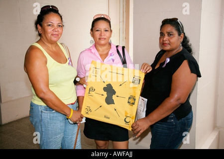 Drei Frauen aus verschiedenen ethnischen Gruppen anzeigen einer Karte von Guyana während einer Protestaktion gegen Gewalt gegen Frauen in Georgetown, Gu Stockfoto