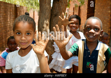 Kinder zeigen ihre sandigen Hände an einem Kindergarten, Gaborone, Botswana, Afrika Stockfoto