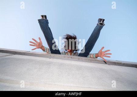 Verrücktes Mädchen an einer Wand, Strecken ihre Arme und Beine Stockfoto