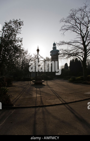 Wrought Eisen Pergola deckt eine Statue mit dem Glockenspiel Glockenturm im Hintergrund, Loughborough, Leicestershire, England. Stockfoto