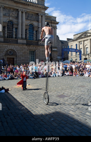 dh Edinburgh Fringe Festival ROYAL MILE EDINBURGH Street Entertainer mono Zyklus jonglieren fangen junge Helfer baton Stockfoto