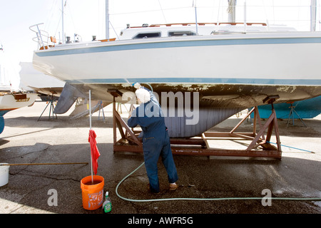 Mann Waschen sein Segelboot im Verankerungsbereich Marina St. Clair Shores Michigan USA Stockfoto