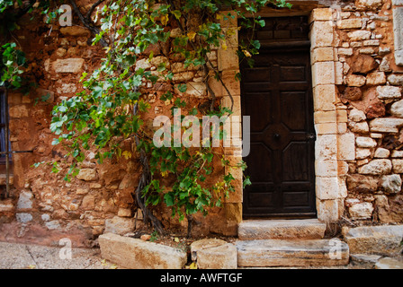 braune Tür in rote Wand in Roussillon, Provence, Frankreich, September 2006 Stockfoto