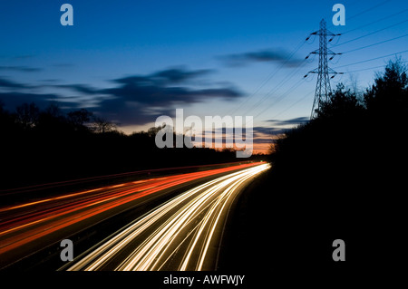 Verkehr-Trails auf zweispurigen A3 in der Nähe von Guildford bei Sonnenuntergang Surrey England UK Stockfoto