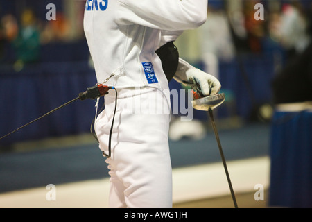 FECHTSPORT Wettbewerb Frau Holding Degen Waffe nah oben und Seitenansicht der Mittelteil Elektroanschluss Uniformjacke Stockfoto