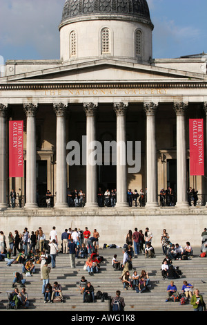 Sightseeing auf dem Trafalgar Square Touristen sitzen auf wenige Schritte vor der National Gallery Welt berühmten Attraktionen Londons England UK Stockfoto