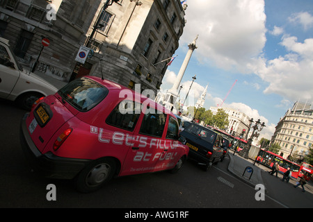 Hell rosa London Taxi Taxi warten auf Ampel in der Nähe von Trafalgar Square und Nelsons Spalte London England UK EU Stockfoto