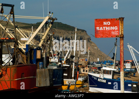 Kein Baden Zeichen und Angelboote/Fischerboote auf Felsen Nore Strand der Stade alt Stadt Hastings East Sussex England Großbritannien UK Stockfoto