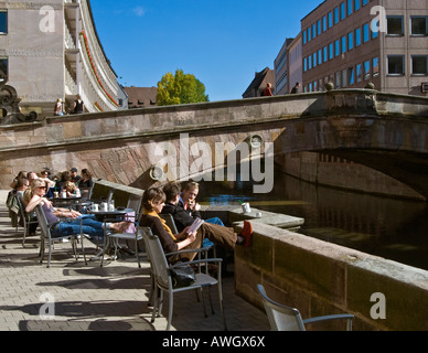 Menschen am Fluss Starbucks-Café-Terrasse, Blick auf Fleisch Brücke (Fleischbrücke), Pegnitz Ufer, Nürnberg Stockfoto