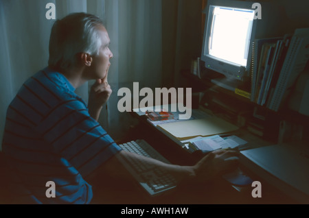 Ein Mann mittleren Alters arbeiten am Computer in seinem Büro zu Hause in SLC, Utah, USA. Bewegung & Transparenz zeigt sich aufgrund der langen messen. Stockfoto