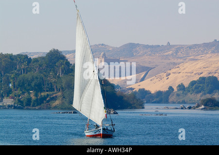 Felucca gleitet entlang des Nils von Kitchener Insel (El Nabatat Insel) Assuan, Ägypten mit Aga Khan Mausoleum auf dem Hügel in der Ferne Stockfoto