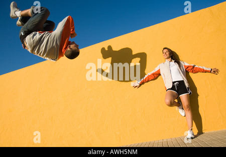 Stützte sich auf Yellor Wand, Saltos auf vor ihr Mann Frau Stockfoto