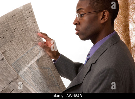 Afrikanische amerikanische Mann liest Zeitung Börse Bericht USA Stockfoto
