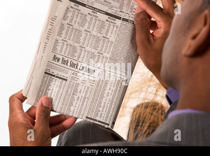 Afrikanische amerikanische Mann liest Zeitung Börse Bericht USA Stockfoto
