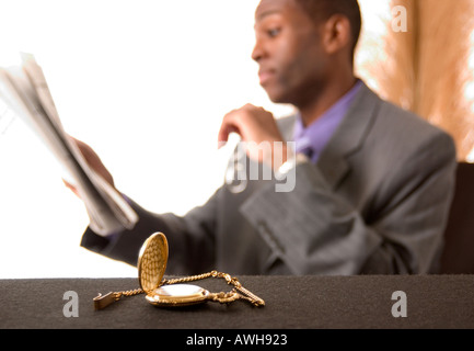 Afrikanische amerikanische Mann liest Zeitung Börse Bericht USA Stockfoto
