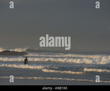 Blick nach Norden auf Lindisfarne Burg durch Surf Surfer von Bamburgh Strand Northumberland Nordengland August 2007 Stockfoto