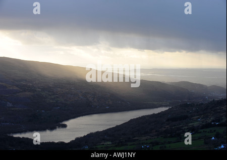 Blick über Fachwen und Llyn Padarn in Richtung Caernarfon in Nordwales während einer Schneedusche. Stockfoto