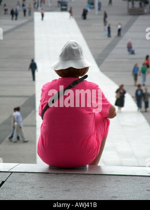 Frau sitzt auf den Stufen des La Grande Arche in die Geschäftsviertel von La Defense in Paris Stockfoto