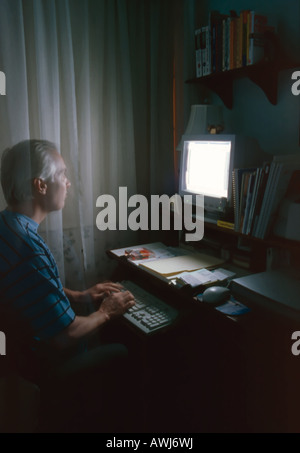 Ein Mann mittleren Alters arbeiten am Computer in seinem Büro zu Hause in SLC, Utah, USA. Bewegung & Transparenz zeigt sich aufgrund der langen messen. Stockfoto