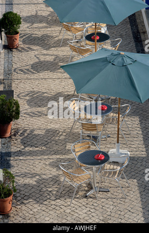Ein Café im Freien auf einem gepflasterten Platz mit Stühlen, Tischen und Sonnenschirmen Stockfoto